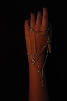 Elegant dark navy nails with a glossy finish paired with silver minimalist line art on a chic bracelet-adorned wrist.