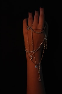 Elegant dark navy nails with a glossy finish paired with silver minimalist line art on a chic bracelet-adorned wrist.