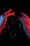 a pair of hands holding onto a chain
