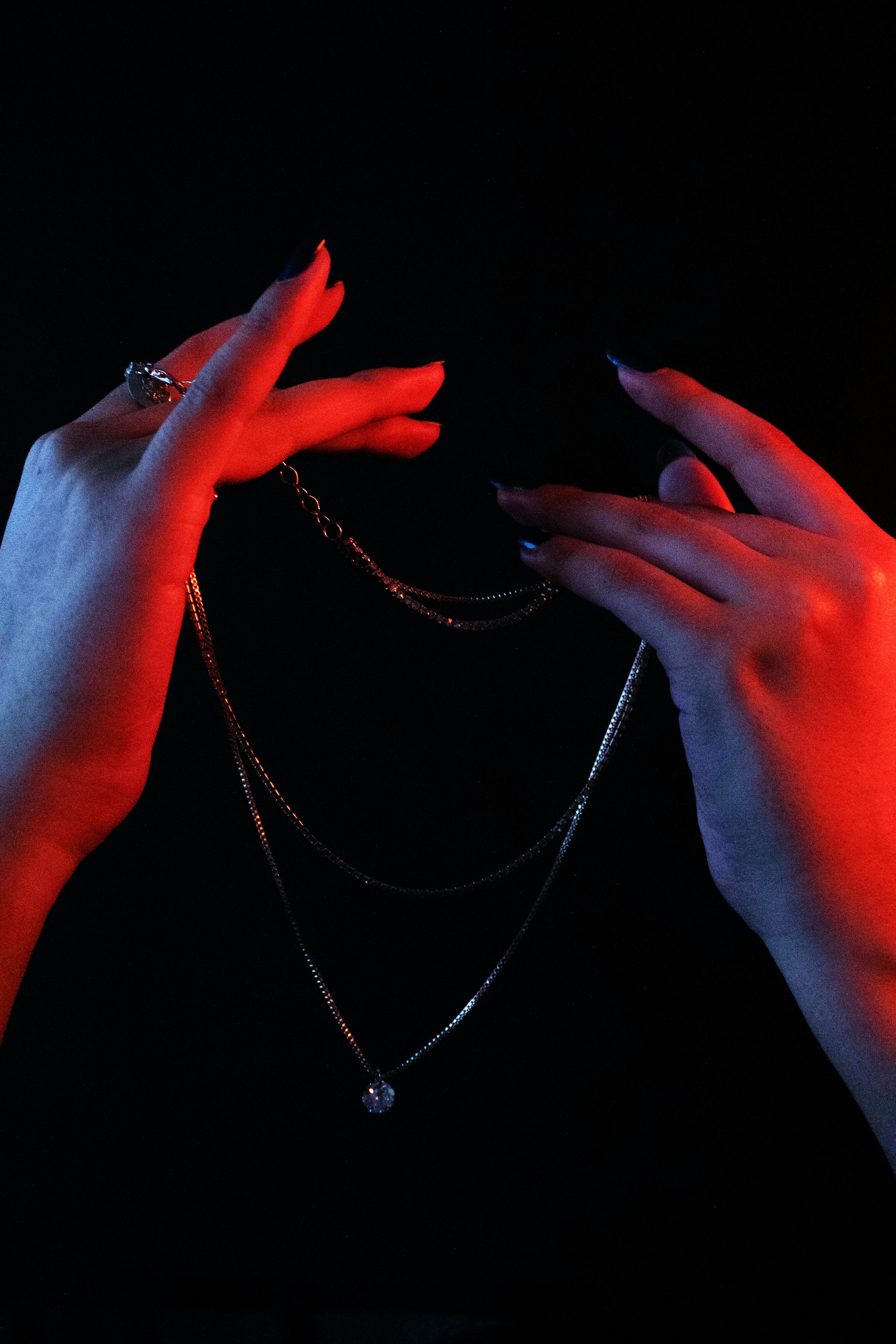 a pair of hands holding onto a chain