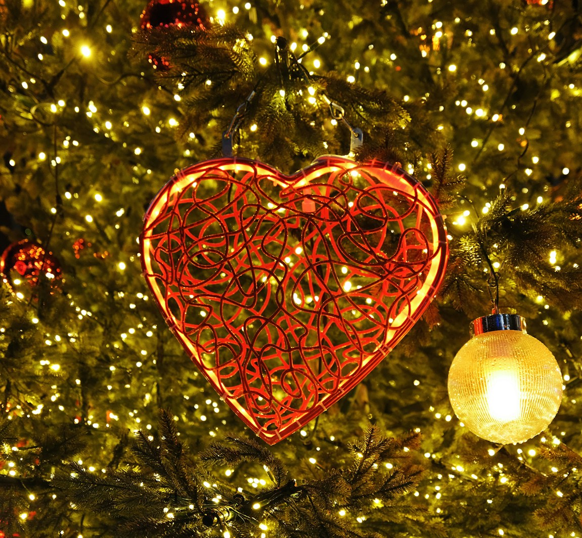 a heart shaped ornament hanging from a christmas tree