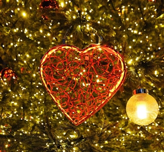 a heart shaped ornament hanging from a christmas tree