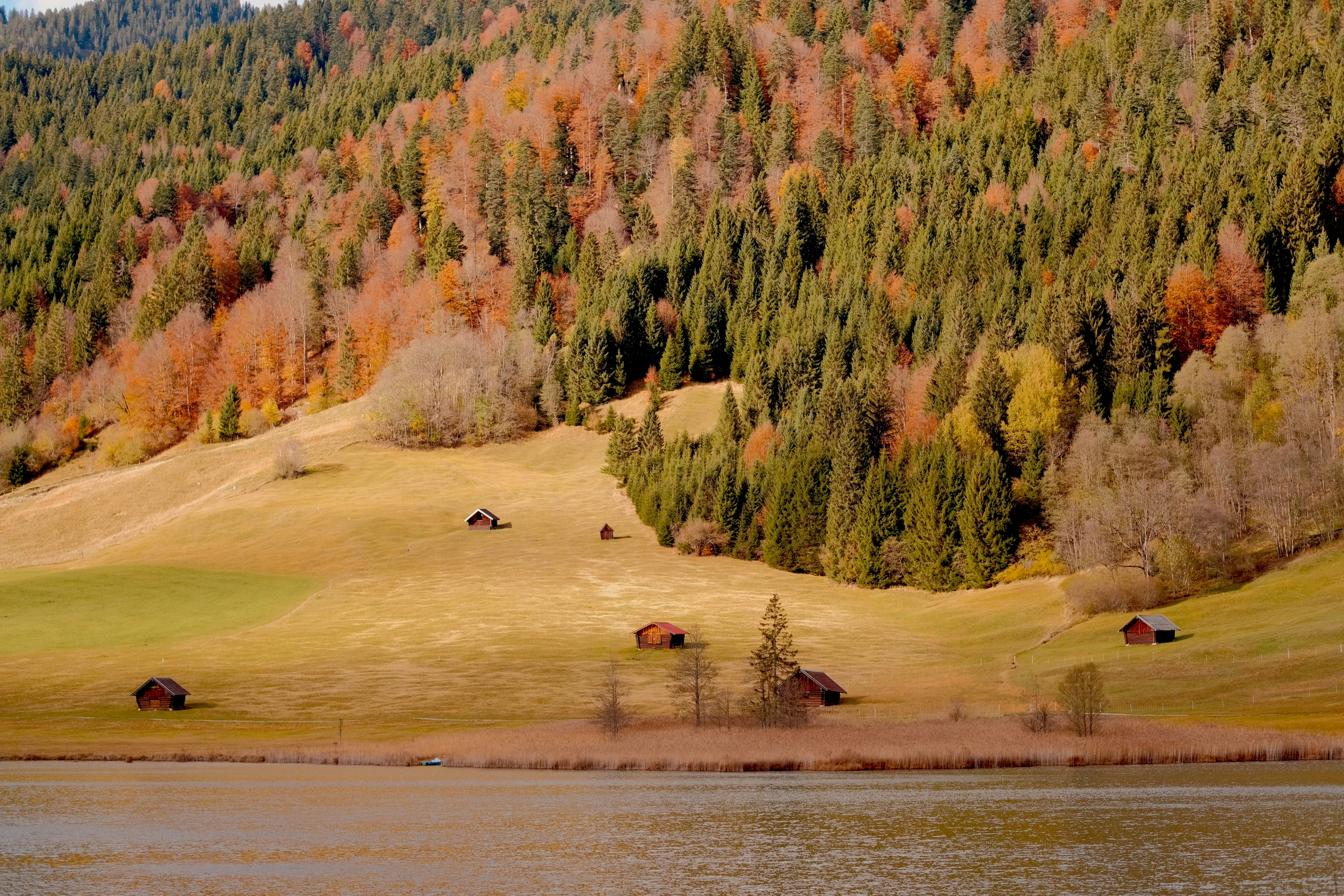 a scenic view of a mountain with a lake in the foreground, 