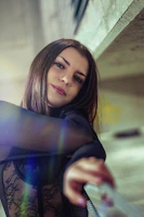 Zainab- a woman is posing for a picture while holding a cell phone