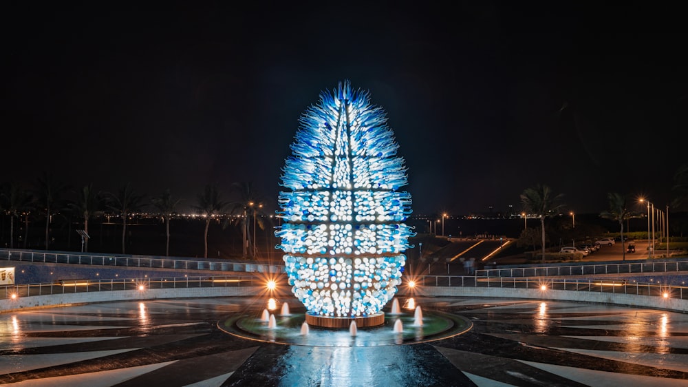 a lit up christmas tree in the middle of a plaza