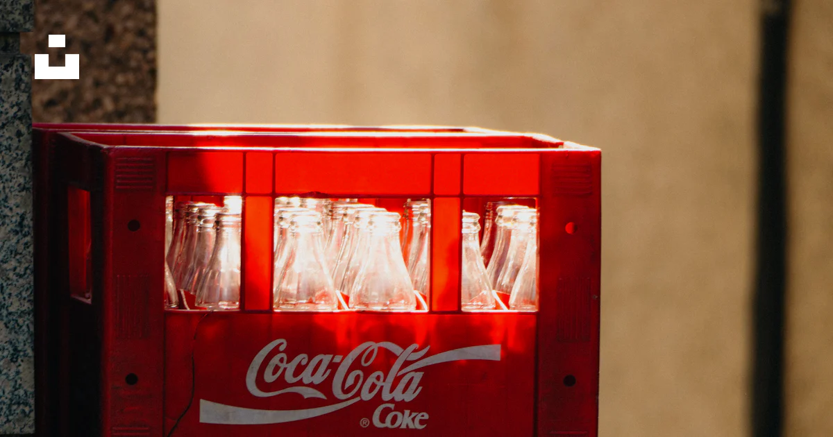 A red coca - cola machine sitting on the side of a building photo ...