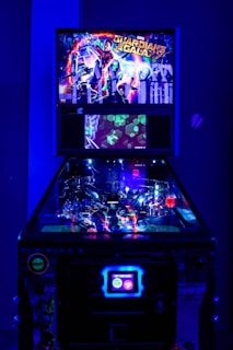 A brightly lit pinball machine themed around Guardians of the Galaxy. The marquee displays vibrant artwork featuring characters and scenes from the franchise surrounded by neon lights. The playfield is illuminated with various colorful lights and features typical pinball components like flippers, bumpers, and ramps.