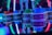 Stacks of tickets are arranged on a reflective surface, featuring various numerical values. Vibrant neon lights in red, blue, and green create a lively, arcade-like atmosphere, casting colorful reflections.