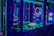 A brightly lit arcade game machine featuring neon lights and colorful graphics. The display shows point values and bonus levels, with vibrant colors reflecting off the glass and surrounding surfaces.