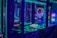 A brightly lit arcade game machine featuring neon lights and colorful graphics. The display shows point values and bonus levels, with vibrant colors reflecting off the glass and surrounding surfaces.