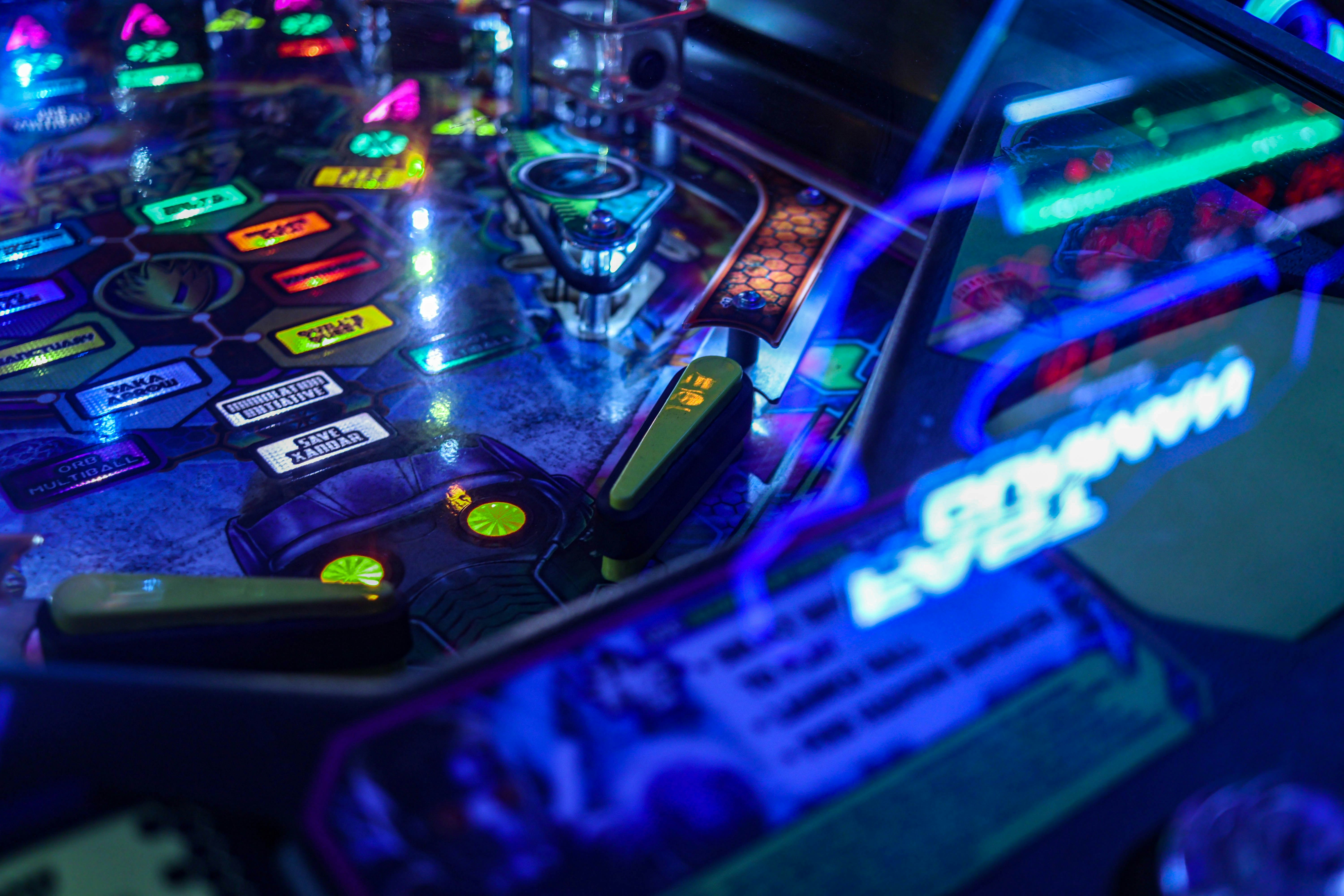 a close up of a pinball machine with neon lights