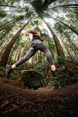 Close-up of a person’s legs in motion on a forest trail, highlighting natural movement.