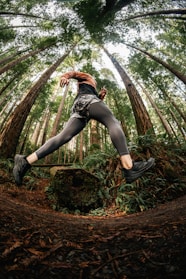 A vibrant photo of a person jogging on a forest trail wearing sleek, breathable outdoor activewear.