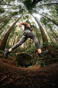 Runner mid-stride on a trail, showcasing smooth efficient running form.