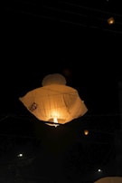 Students celebrating a festival with lanterns glowing warmly in the evening sky.