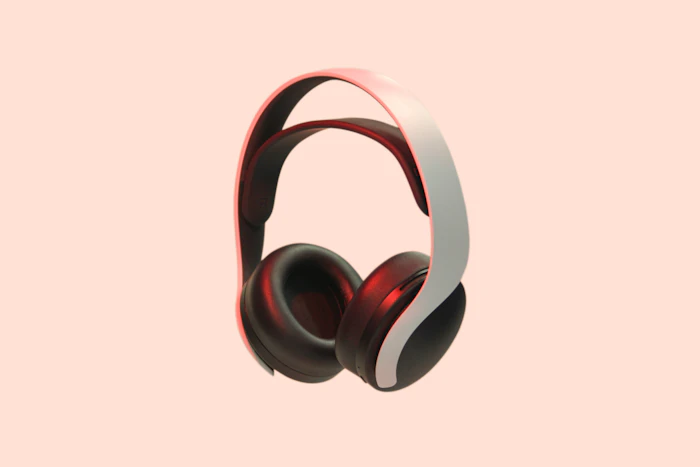 White and black over-ear headphones on a peach background