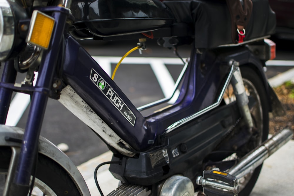 a blue scooter parked on the side of the road