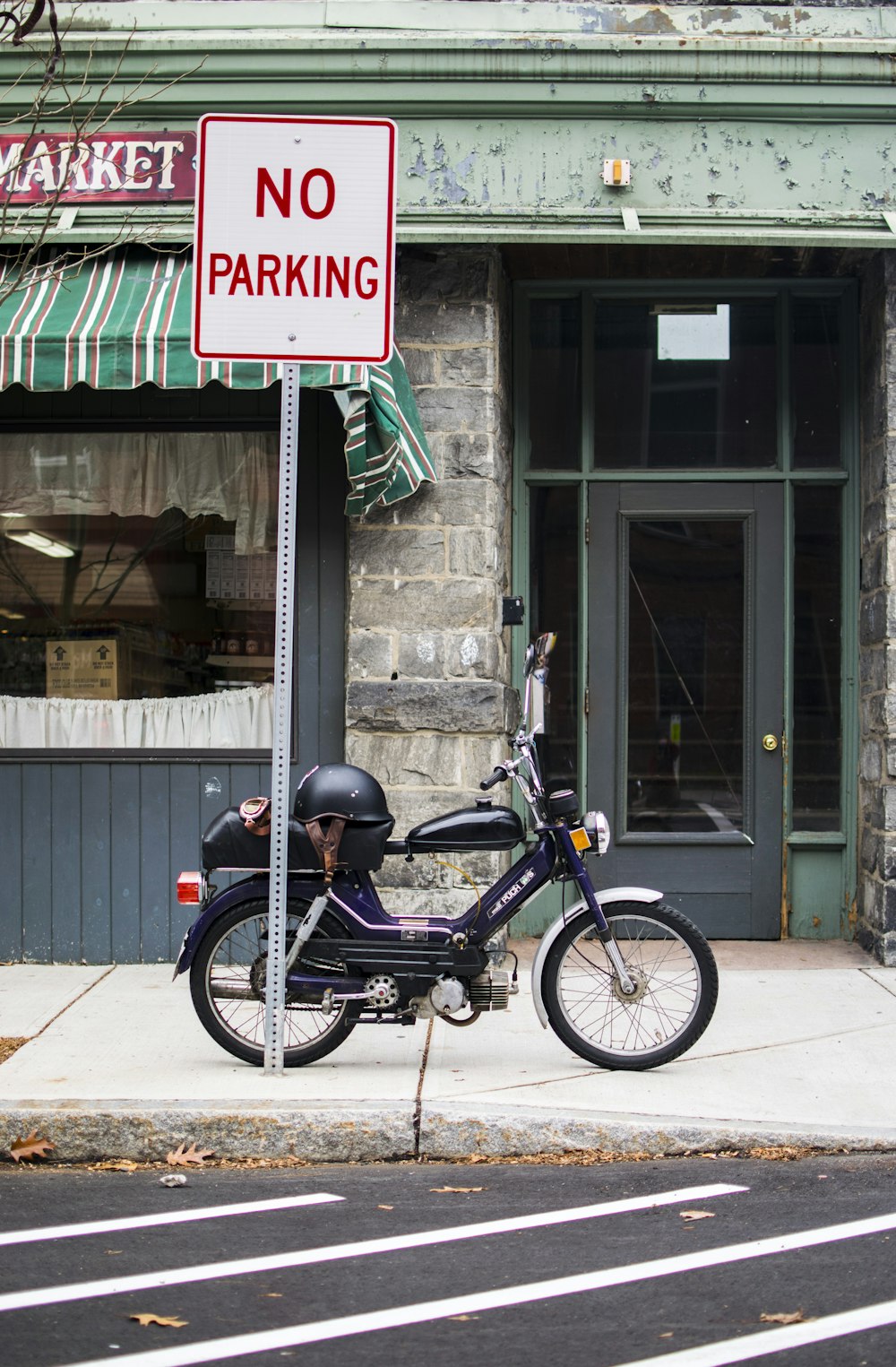 a motorcycle parked next to a no parking sign