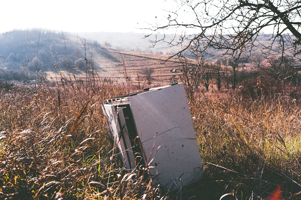 a refrigerator sitting in the middle of a field