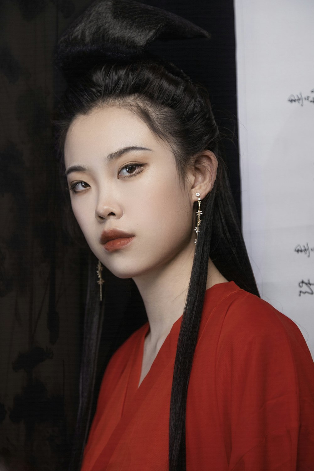 a woman with long black hair wearing a red shirt