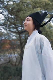 A model wearing a flowing traditional eastern outfit in a natural outdoor setting.