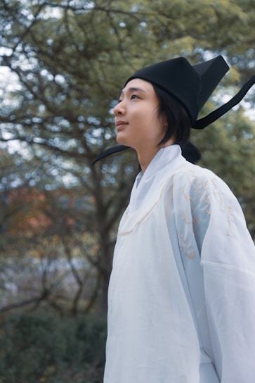 A model wearing a flowing traditional eastern outfit in a natural outdoor setting.