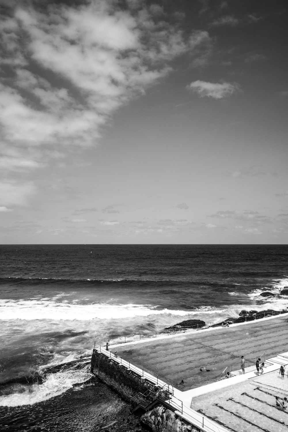 a black and white photo of a beach and ocean