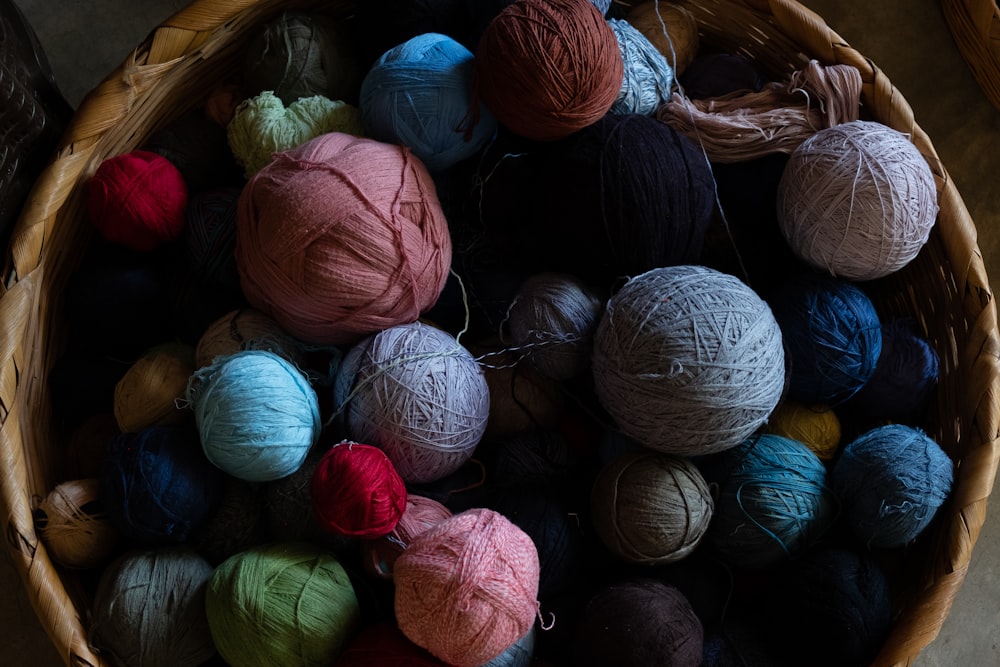 a basket filled with balls of yarn on top of a table