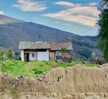 a small house sitting on top of a lush green hillside