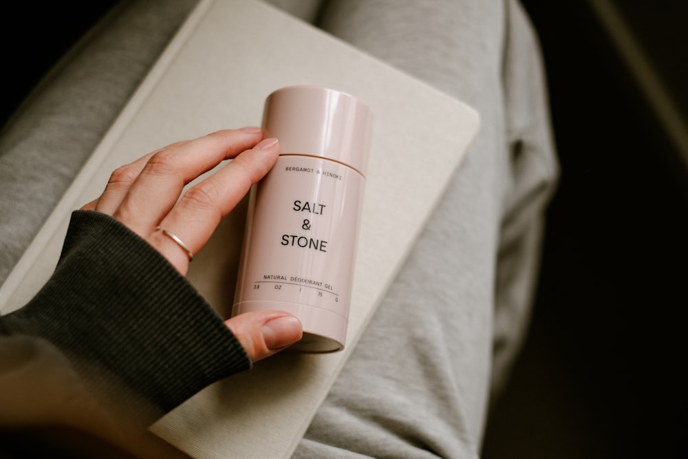 a person holding a bottle of salt and stone