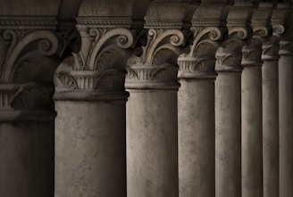 a row of pillars with a clock on top of them