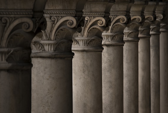 a row of pillars with a clock on top of them