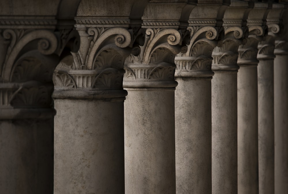 a row of pillars with a clock on top of them