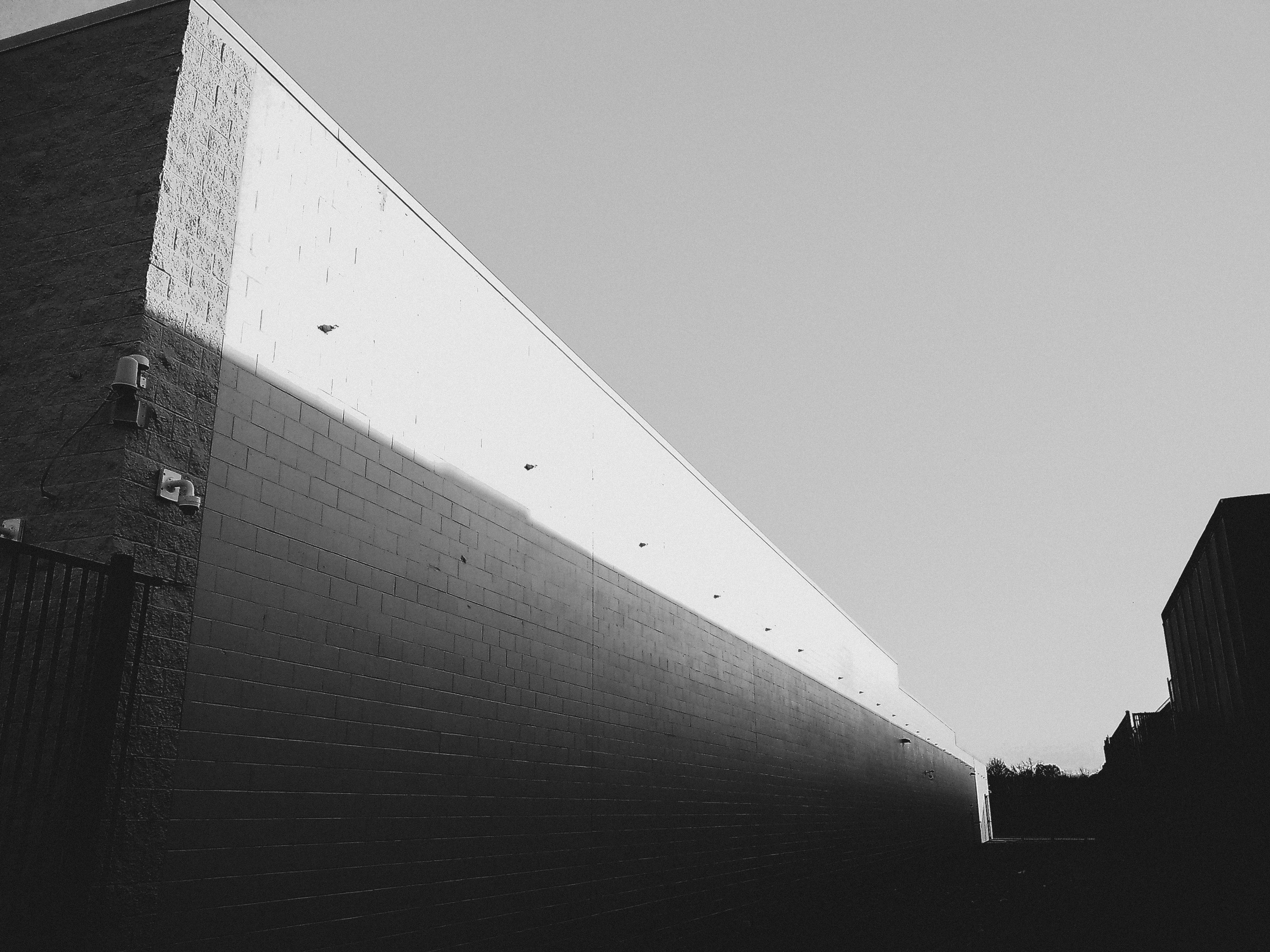 Black and white brick building with moody shadows