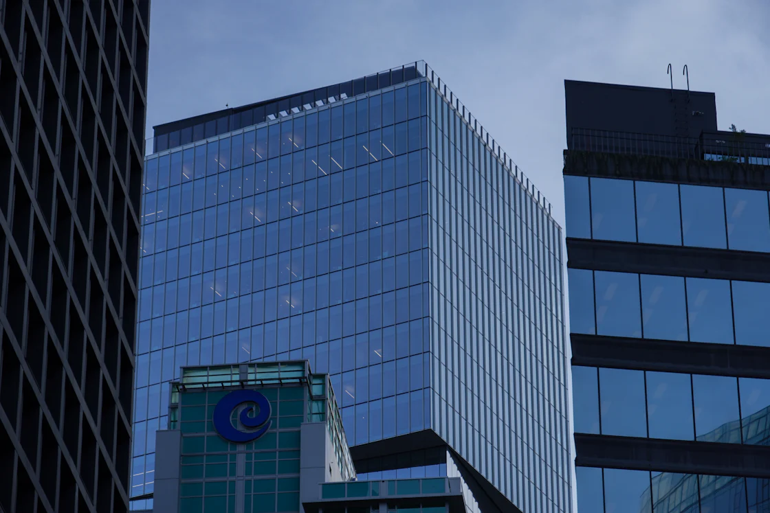 Two tall corporate buildings sitting next to each other against the sky