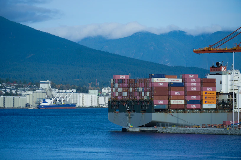 A sleek container ship docked at Gothenburg port, ready to unload diverse global products.