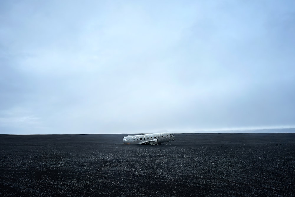 a small airplane sitting on top of a black field