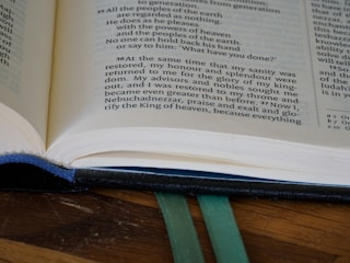 An open Bible resting on a wooden table.