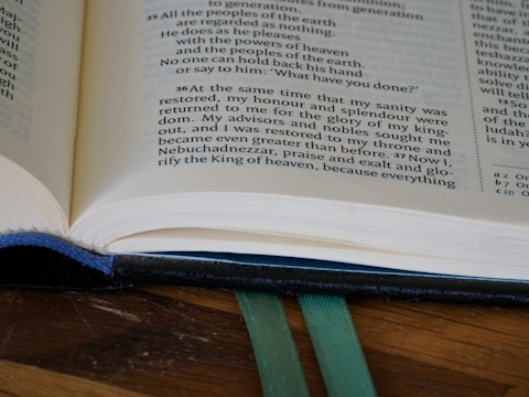 An open Bible resting on a wooden table.