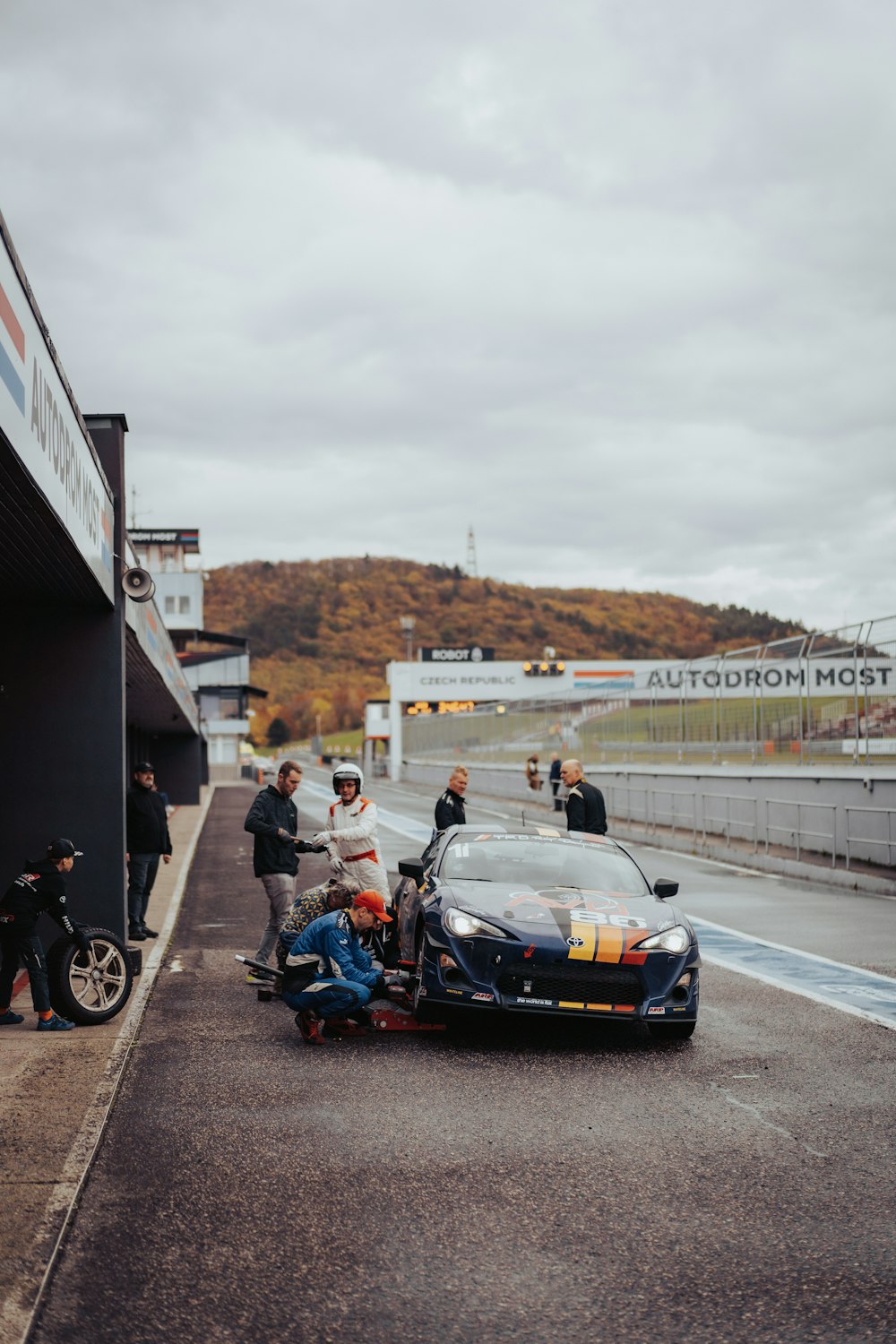 a car is being worked on by a man on a motorcycle