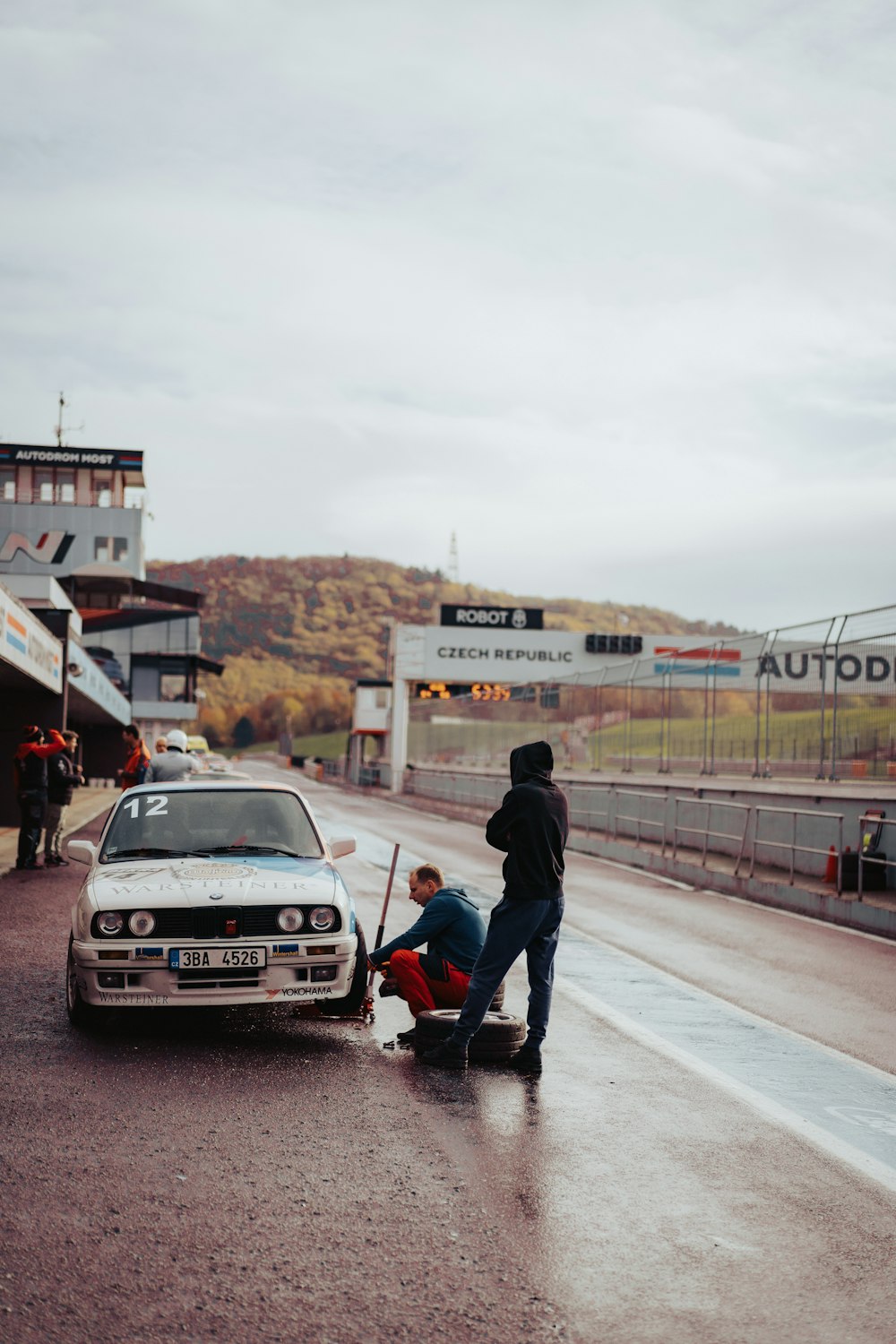 a man fixing a car on the side of the road