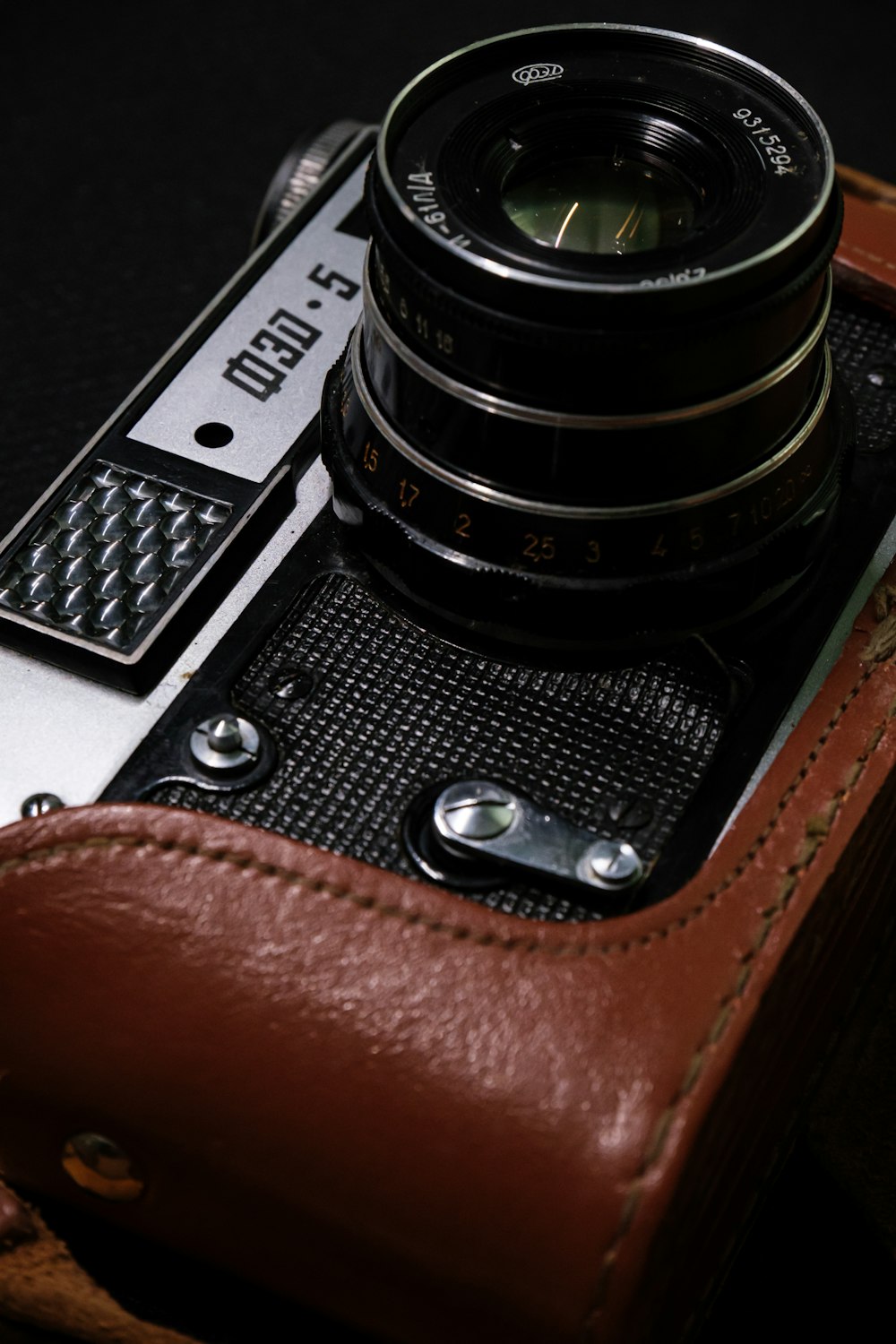 a close up of a camera with a leather case