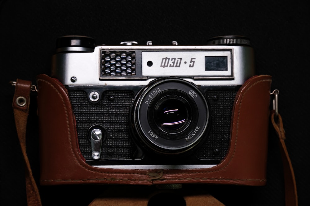 an old camera with a leather case on a black background