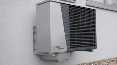 Close-up of a heat pump system with technician performing maintenance