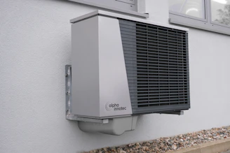 Modern aerothermal heat pump setup outside a single-family home.