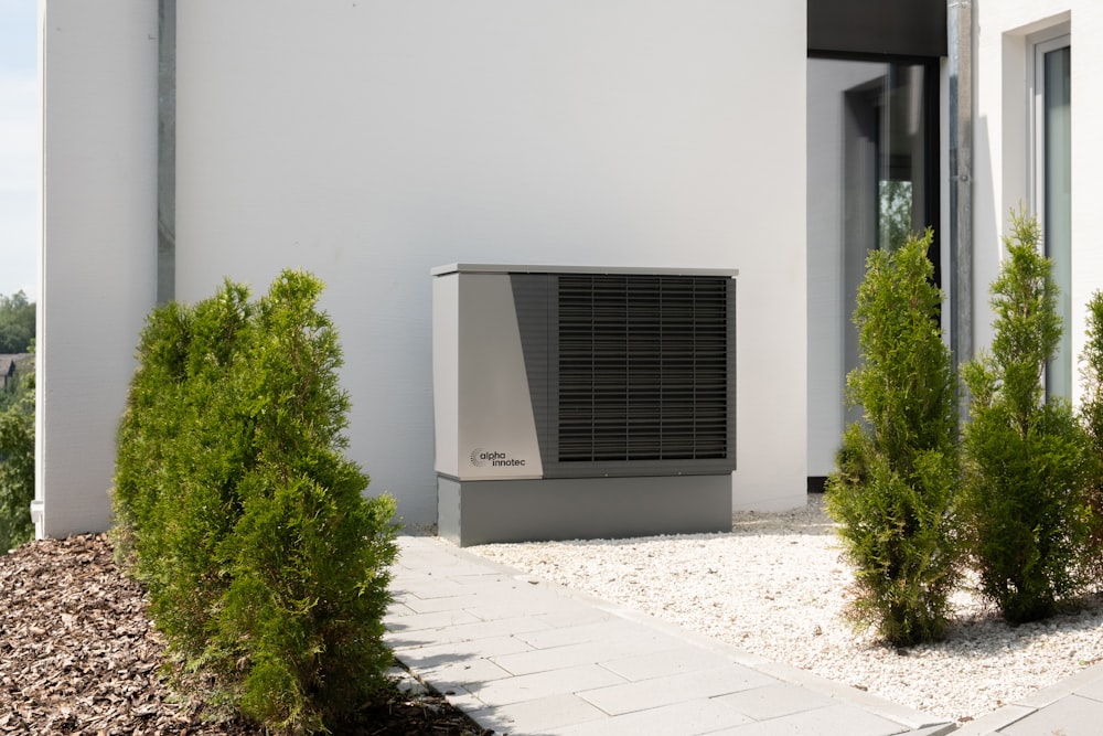 Un acondicionador de aire sentado en el costado de un edificio