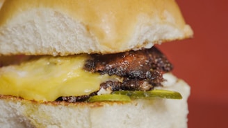 Close-up of a juicy hickory smoked burger with melted cheese and fresh toppings.