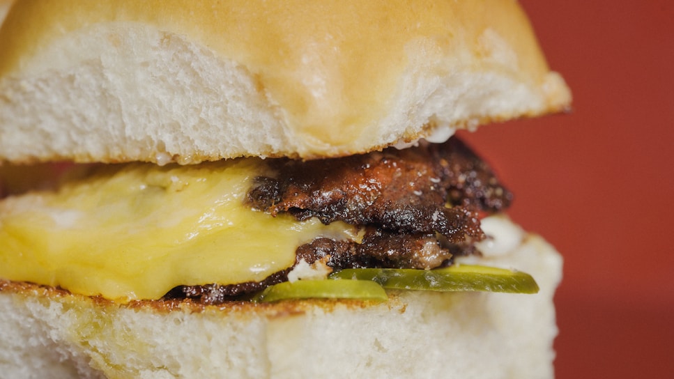 Close-up of a juicy smash picaña burger with melted cheese and fresh lettuce on a toasted bun.