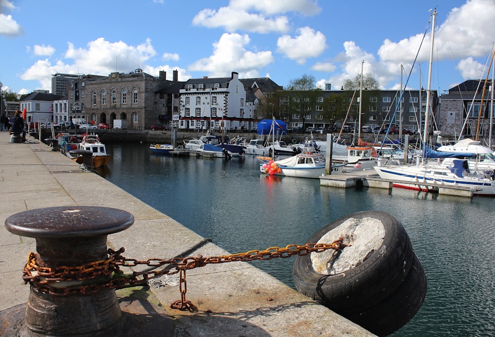 a harbor filled with lots of boats next to tall buildings