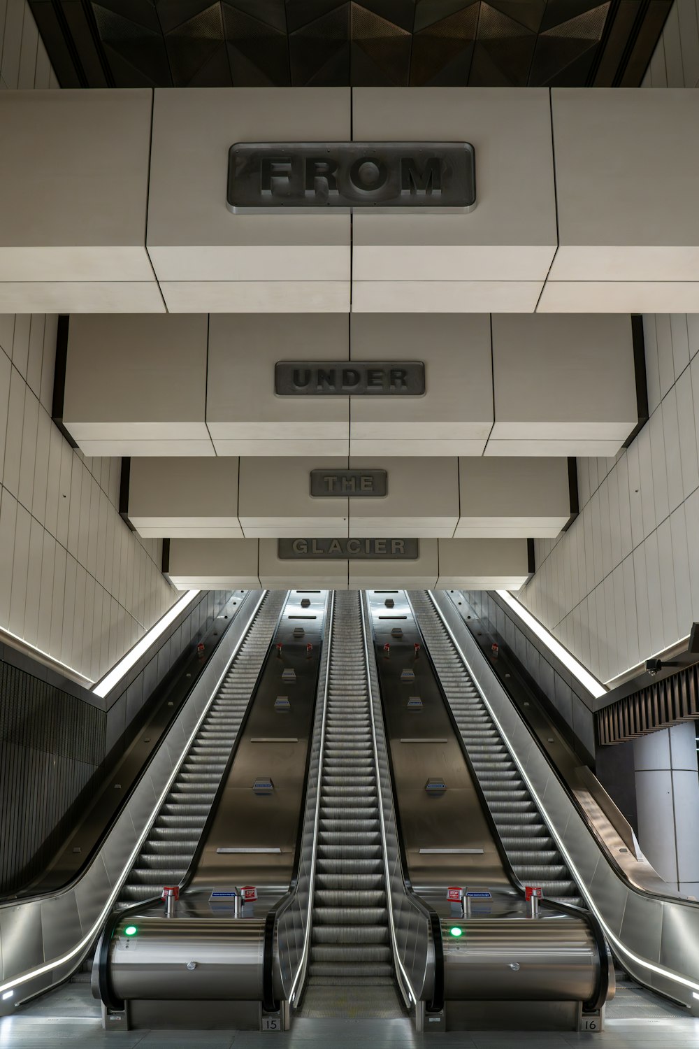 eine Rolltreppe in einem Gebäude mit einem Schild darüber